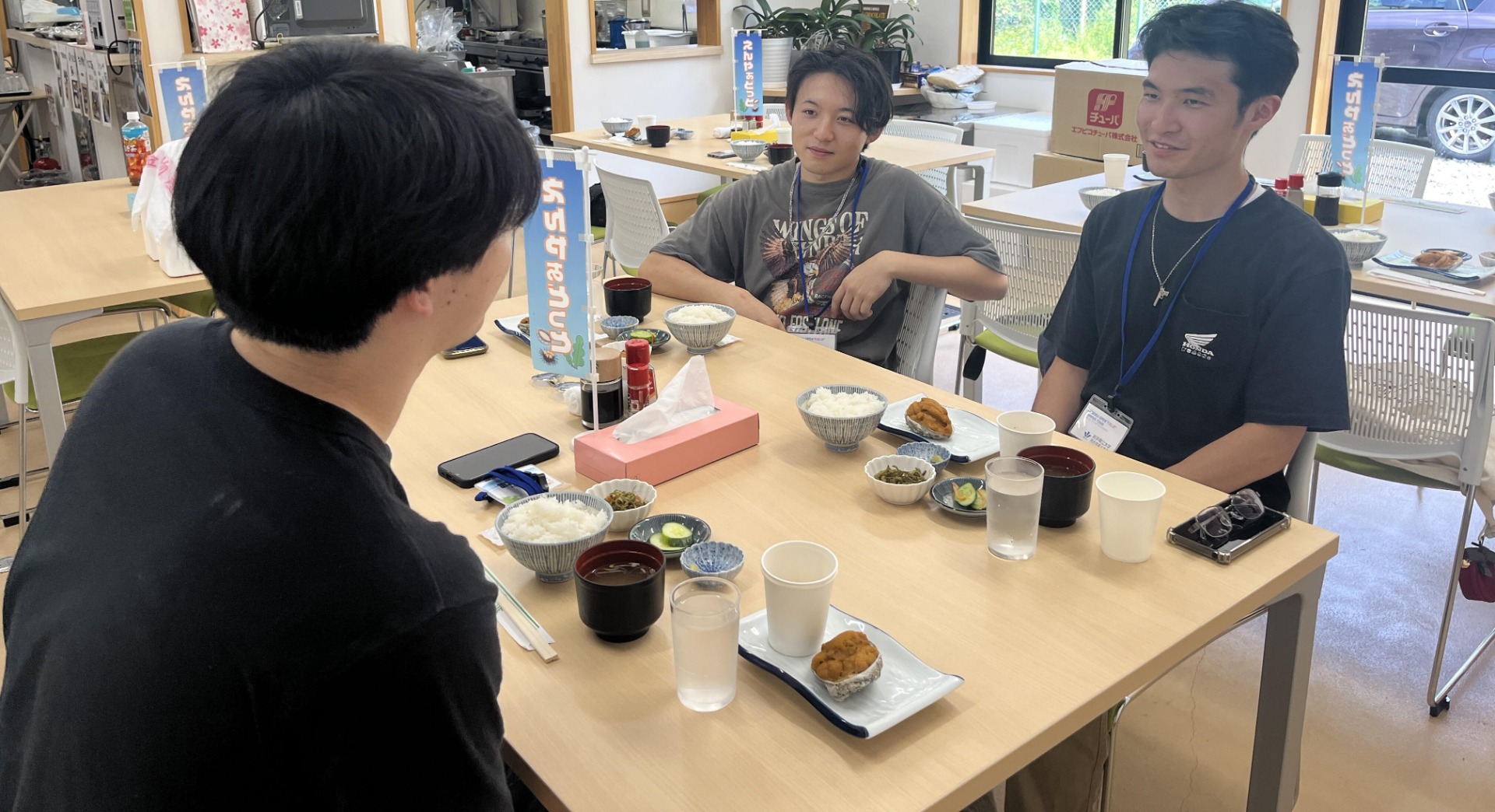 食事をしながら、談笑している学生